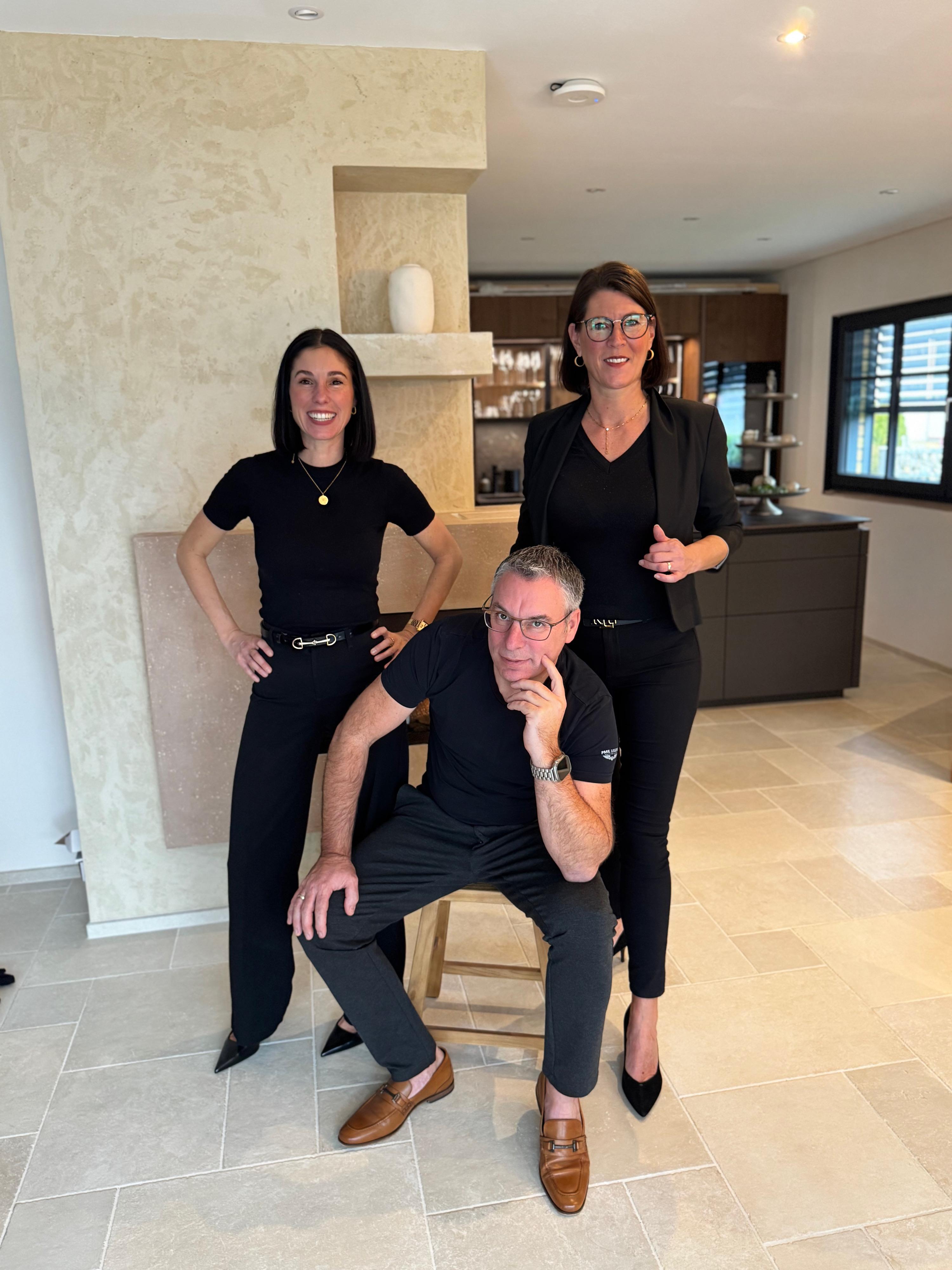 Team der Wohnwert Haus- & Immobilienverwaltungs GmbH in einem modernen Innenraum